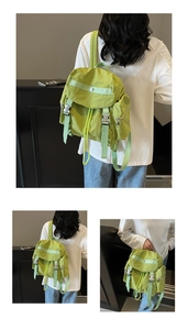Detail of light green nylon backpack featuring buckle closure and drawstring opening