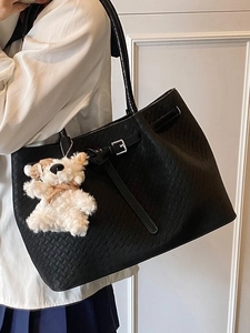 Fashionable black woven leather bucket bag with cute bear charm and shoulder strap