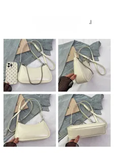 Detail view of cream leather underarm bag with silver chain and adjustable shoulder strap