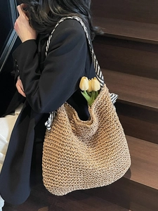 Large straw beach tote bag with striped shoulder straps for summer beach holidays