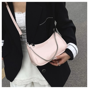 Detail of light pink patent leather crescent bag with silver chain and adjustable strap