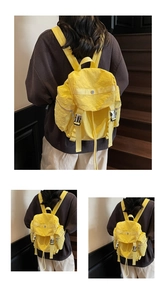 Detail of bright yellow nylon backpack featuring flap cover and metal buckle closures