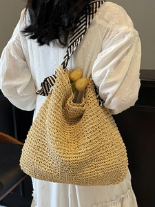 Large beige woven straw beach bag with striped ribbon straps and floral decoration