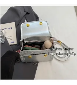 Detail of silver embossed crossbody bag interior showing spacious storage and magnetic closure
