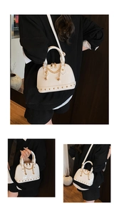 Detail of white glossy shell bag featuring gold rivets and elegant chain ornament