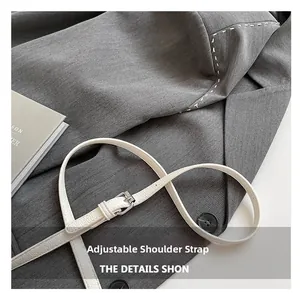 Détail de la bandoulière réglable blanche à texture litchi avec boucle argentée sur sac