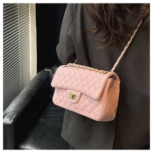 Detail of pink quilted faux leather shoulder bag with golden chain and metal clasp