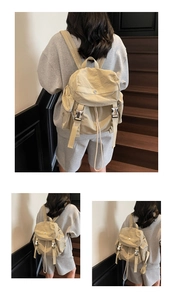 Close-up of khaki nylon backpack with metal buckles and drawstring closure details
