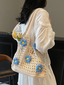 Hollow out crochet tote bag with 3D floral accents worn by a model in a summer dress