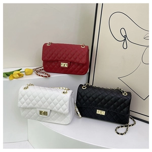 Detailed close-up of quilted lattice chain bags in red, white and black with turn-lock