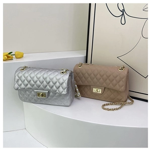 Detailed close-up of quilted leather flap bags in silver and beige with gold chain straps