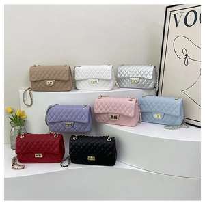 Quilted chain cross-body bags displayed in multiple colors on a minimalist pedestal