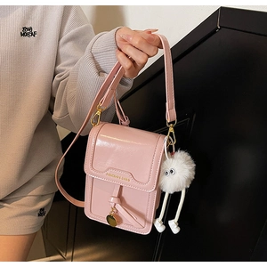 Pink glossy crossbody bag with gold fashion text and white plush cartoon charm
