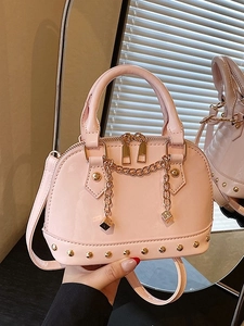 Pink patent leather shell handbag with gold rivets and chain charms for women