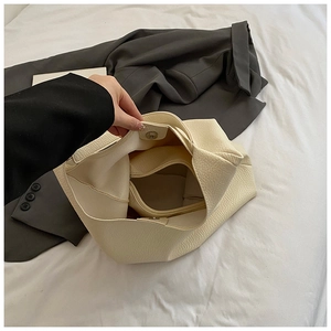 Detail of cream pebbled leather tote bag with magnetic closure and inner pouch