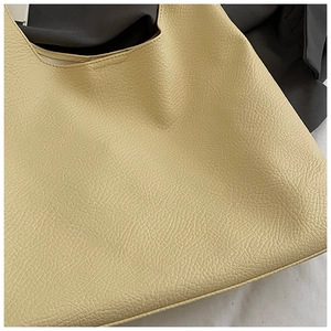 Close-up of the beige large tote bag showing high-quality lychee grain leather texture