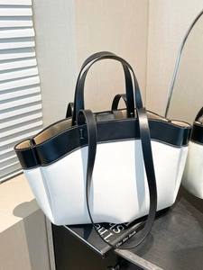 Minimalist black and white large leather tote bag with dual handles in lifestyle setting