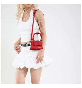 Détail du mini sac en cuir grainé rouge avec logo de mode et poignée renforcée