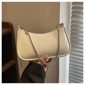 Detail of cream baguette bag with silver chunky chain and brand lettering on leather