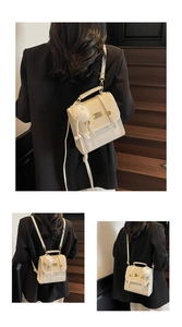Close-up of cream multifunctional backpack with woven details and gold hardware