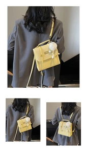 Detail of yellow versatile backpack with woven flap, fuzzy pompom, and multi-way straps