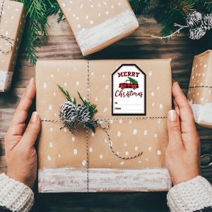 Close-up of buffalo plaid truck Christmas gift label on a kraft paper parcel