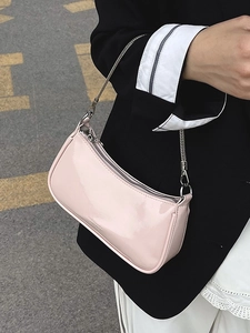Minimalist light pink patent leather underarm bag with silver chain strap and half-moon shape