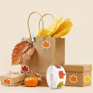 Detail of maple leaf stickers with gold edges on gift packaging for fall decorations