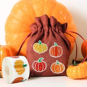 Sparkling autumn pumpkin stickers on a burlap bag with festive orange decor background