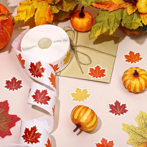 Macro shot of maple leaf stickers with gold edges on envelopes for autumn party decor