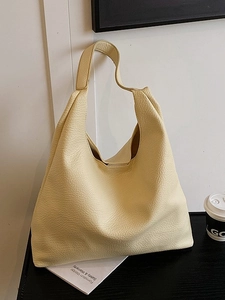 Minimalist large leather tote bag in soft yellow with pebbled texture and hobo shoulder strap