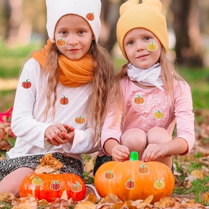 Sparkly orange pumpkin stickers for Halloween decor shown with children in an autumn park