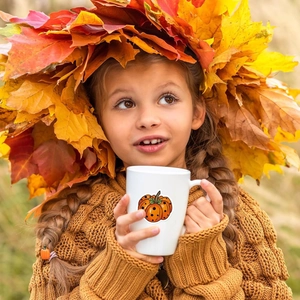 Autocollant de citrouille d'automne sur un mug en céramique dans un cadre automnal doux