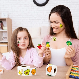 Close-up of colorful fruit and vegetable smiley stickers on rolls for children's rewards