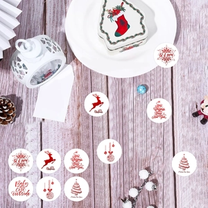 Autocollants de Noël rouges avec renne et sapin sur bureau en bois, vue à plat