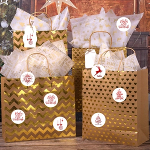 Sacs cadeaux à motifs dorés avec autocollants Merry Christmas sur fond de bois