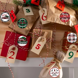 Close-up of buffalo plaid Christmas stickers with reindeer and snowman on gift wrap