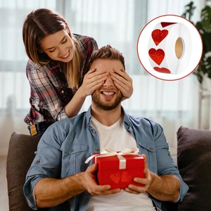 Close-up of sparkling red heart glitter stickers on gift box for Valentine's Day decor