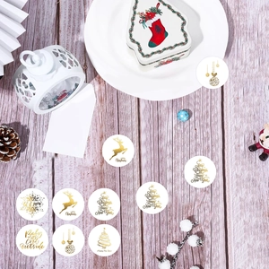 Gros plan d'autocollants de Noël dorés avec motifs de rennes et flocons sur bois