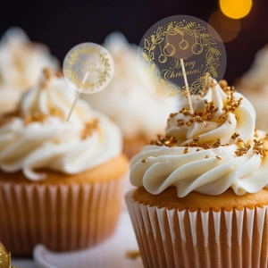 Detail of gold foil Merry Christmas cupcake topper on a frosted cake with festive bokeh