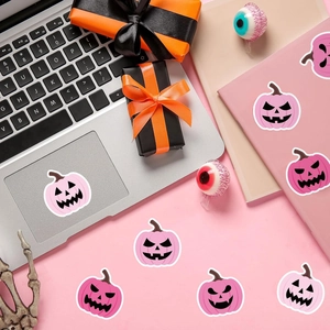 Pink Halloween pumpkin stickers roll with cute Jack-o'-lantern faces for party decor