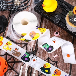Roll of Halloween rubber duck stickers with mummy and vampire designs on wooden background