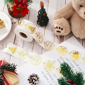 Detail of Christmas gold foil stickers with reindeer and snowflake on white envelope