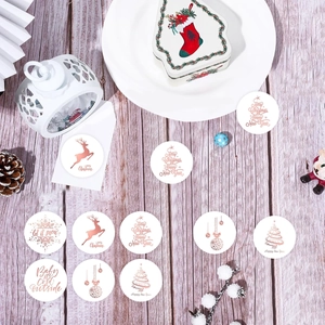 Vue macro d'autocollants de Noël dorés roses sur une table décorative en bois clair
