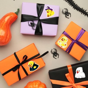 Halloween rubber duck stickers applied to colorful gift boxes with spooky festive decorations