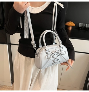 Detail of light blue crossbody bag with ballet-style crisscross ribbons and bow decoration