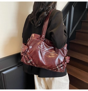 Detail view of deep wine red retro tote bag with metallic buckles and glossy PU texture