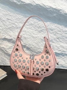 Pink crescent hobo bag with silver studs and double zipper on a contrasting display