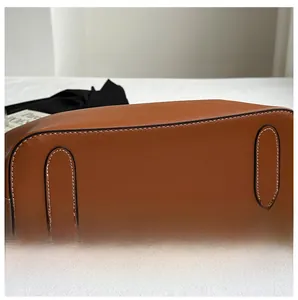 Detailed close-up showing precision white stitching on the brown leather bag base