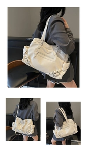Detail view of large cream tote bag with vintage metal buckles and textured leather finish